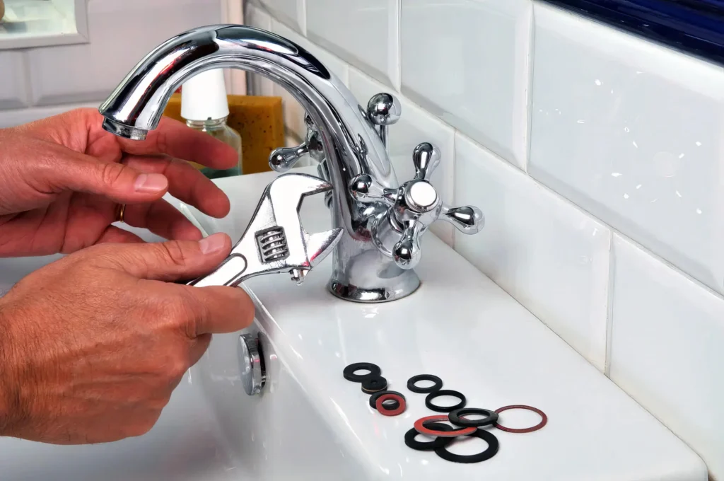 Plumber performing maintenance on a bathroom faucet in San Bernardino