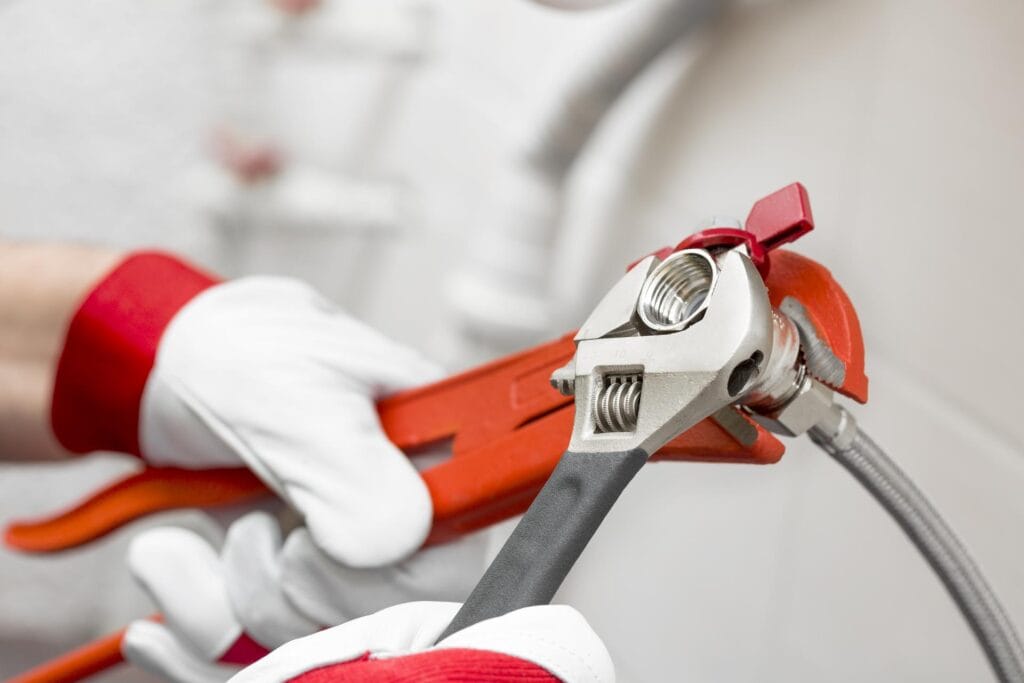 Plumber holding pipe wrenches for an emergency repair in San Bernardino