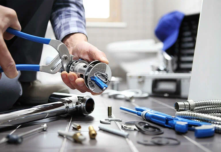 Technician repairing a plumbing fixture with professional tools in San Bernardino