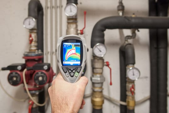 Plumber using a thermal imaging camera to inspect pipes in San Bernardino